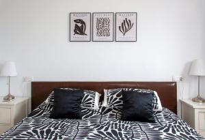 Un dormitorio con una cama con tres cuadros en la pared. en Townhouse overlooking golf course, en Las Armeras