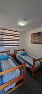 a bedroom with three beds in a room at zpartment in Copiapó