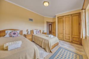 a bedroom with two beds and a large window at Casa Vista Cumeada in Canhestros +31 photos