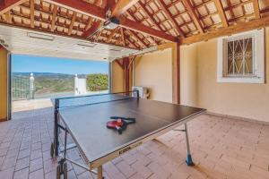 a ping pong table in the middle of a room at Casa Vista Cumeada in Canhestros