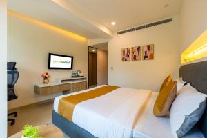 a hotel room with a bed and a tv at Limewood Signature - Golf Course Road in Gurgaon