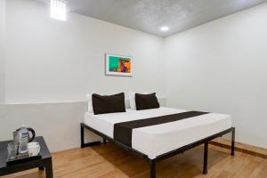 a bedroom with a bed in a room at Hotel O Sky Villa in Nagpur