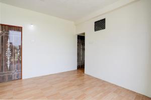 an empty room with white walls and a wooden floor at Hotel O Sky Villa in Nagpur