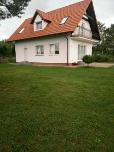 a white house with a red roof and a yard at Agroturystyka Renatka 