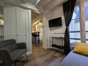 a living room with a couch and a tv on a wall at Escale in Beauvais