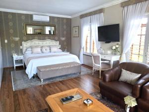 una camera da letto con un letto, un divano e un tavolo di Meerendal Cottage-Affordable Luxury-Private Garden with Pool & Hot Tub a Città del Capo Altre 39 foto