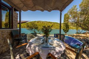 a table on a patio with a view of the water at Villa Zora ZadarVillas - private island retreat in Sali
