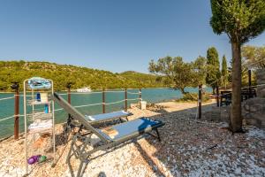 a beach chair and a slide next to the water at Villa Zora ZadarVillas - private island retreat in Sali
