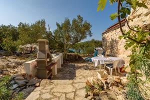 a stone patio with a table and a stove at Villa Zora ZadarVillas - private island retreat in Sali +18 photos