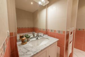 a bathroom with a sink and a large mirror at L'Arcadia Panoramique - Terrasse Vue Lac et Piscine in Talloires +6 photos