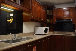 アル・コバールにあるوردة الرمال للأجنحة الفندقيةのキッチン(木製キャビネット、シンク、電子レンジ付)