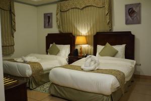 アル・コバールにあるوردة الرمال للأجنحة الفندقيةのホテルの部屋にはタオルが敷かれたベッドが2つある