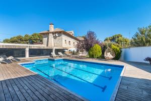 einen Pool auf einer Terrasse mit einem Haus in der Unterkunft Casa Valfonda in Torres de Barbués