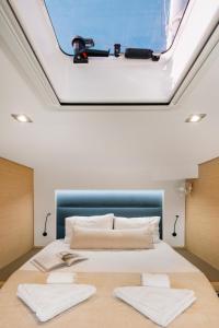 a bedroom with a large bed with a skylight at Dione Catamaran in Thessaloniki