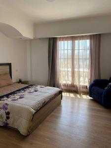 a bedroom with a bed and a large window at One bedroom old town tawaya Sahel hashish in Hurghada