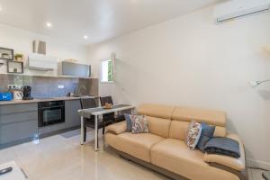 Una sala de estar con un sofá y una cocina. en Appartement indépendant avec jardin, en Pont de lʼArc 14 fotos más