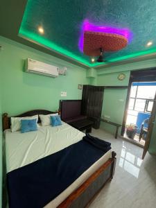 1 dormitorio con 1 cama grande y techo verde en Panmozhi residency, en Tiruvannāmalai