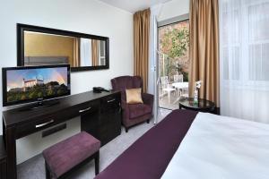 um quarto de hotel com uma cama e uma televisão de ecrã plano em APLEND CITY Hotel Perugia em Bratislava