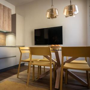 a dining room with a table and chairs and a tv at Casa Abelia - Boutique Apartment in Venice