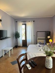 a hotel room with a bed and a table with a table at IL BAGLIO DELL'ETNA VILLA's in Linguaglossa