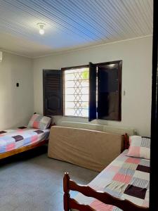 モスケイロにあるCasa Mosqueiro, Praia do Farol e Chapéu Viradoのベッドルーム1室(ベッド2台、窓、バスタブ付)