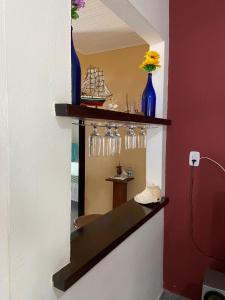 a shelf with glasses and vases on a wall at Casa Mosqueiro, Praia do Farol e Chapéu Virado in Mosqueiro +20 photos