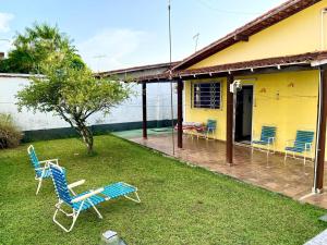 a yard with chairs and a house in the rain at Casa Mosqueiro, Praia do Farol e Chapéu Virado in Mosqueiro