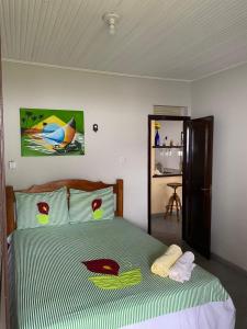 モスケイロにあるCasa Mosqueiro, Praia do Farol e Chapéu Viradoのベッドルーム1室(緑と白の掛け布団付きのベッド1台付)