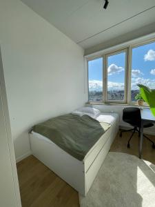 コペンハーゲンにあるNorrebro big aptのベッドと机と窓のある寝室