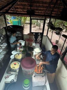 two people preparing food on a table in a tent at AbbA Marari Beach Villas & Homestay Mararikulam in Alleppey