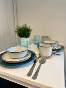 three bowls and spoons sitting on a counter with plates andoons at Cosy Cottage Ambleside in Ambleside +8 photos