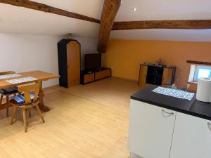 a kitchen and living room with a table and a counter at Appartamento in Attico in Poschiavo