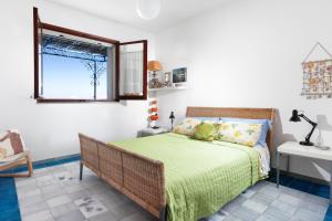 马萨鲁布朗斯Il Respiro del Mare con vista Capri的一间卧室配有一张带绿色床罩的床和窗户。