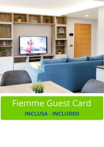 un salon avec un canapé bleu et une télévision dans l'établissement CASA YARA - appartamento moderno, Dolomiti Affitti, à Cavalese