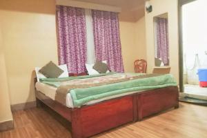 a bedroom with a bed with purple curtains at SnowCap Regency in Gangtok