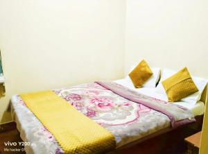 a bed with a blanket and pillows on it at SnowCap Regency in Gangtok +1 photo