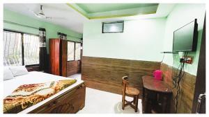 a bedroom with a bed and a desk and a tv at স্বস্তিকা Swash-Tikaa Digha Near Sea Beach AC Or Non AC Room in Digha