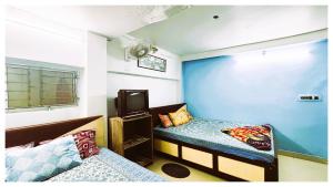 a room with two beds and a tv in it at স্বস্তিকা Swash-Tikaa Digha Near Sea Beach AC Or Non AC Room in Digha