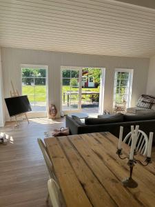a living room with a table and a couch at Vacation home 1 minute away from the Beach in Yderby +38 photos