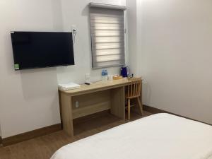 a room with a desk with a television and a bed at Hotel88 in Ấp Bình Hưng