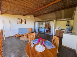 sala de estar con mesa de madera y cocina en Makis' Vallée, en Ampangorinana