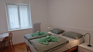 ein Schlafzimmer mit zwei Betten mit grünen Schleifen darauf in der Unterkunft Casa Rio Maggiore in Levico Terme + 3 Fotos