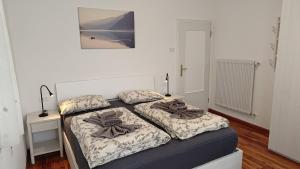 ein Schlafzimmer mit zwei Betten und einem Bild an der Wand in der Unterkunft Casa Rio Maggiore in Levico Terme