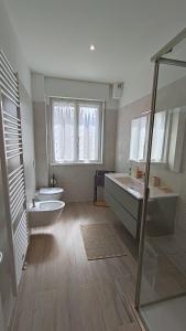 ein großes Badezimmer mit zwei Waschbecken und zwei WCs in der Unterkunft Casa Rio Maggiore in Levico Terme