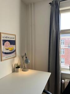 a white desk with a lamp and a window at Stunning 6-Pax Valby in Copenhagen +12 photos