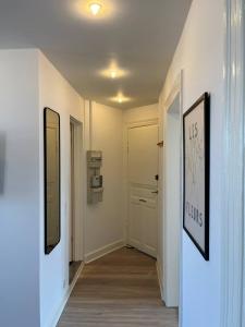 a hallway with two pictures on the wall and a door at Stunning 6-Pax Valby in Copenhagen