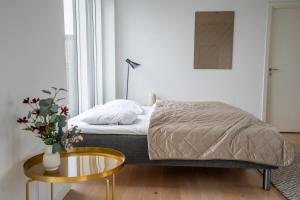 コペンハーゲンにあるLuxury Executive Harbour Penthouseのベッドと花瓶が置かれたテーブルのある寝室