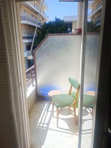 a balcony with two chairs and a table at The cabin in Loutraki +4 photos