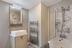 a bathroom with a sink and a shower and a tub at Landal Bryn Morfydd in Llanrhaiadr +8 photos