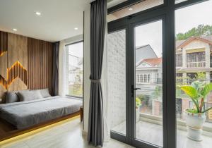ein Schlafzimmer mit einem Bett und einem großen Fenster in der Unterkunft Alley Villa in Xuan An